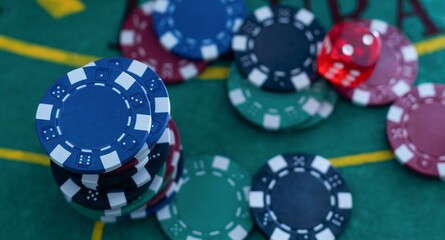Casino. Game chips and dice lie on the table against a blurred dramatic background. Game chips for betting in gambling. Dice. Poker chips.