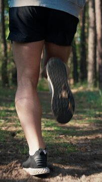 Close up athlete legs running in forest. Runner sprinting and do exercise.