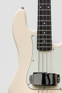 photo of a beige bass guitar on a white background. Musical instrument