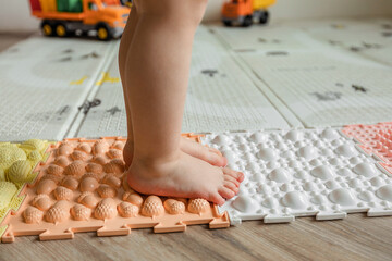 Children's bare feet, walking on an orthopedic massage mat. Prevention of flat feet in children. 