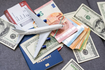 Air tickets, passports, money and toy plane on table