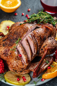 Baked Christmas duck with thyme, berry and orange served on a festive table. vertical image. top view. copy space for text