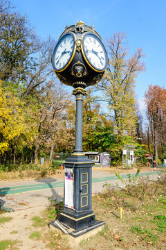 Vintage style black and grey metallic clock towards clear blue sky in  King Michael I Park (Herastrau) Park, in Bucharest, Romania, in a sunny autumn day