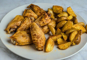 seasoned chicken wings  with a side of potato wedges