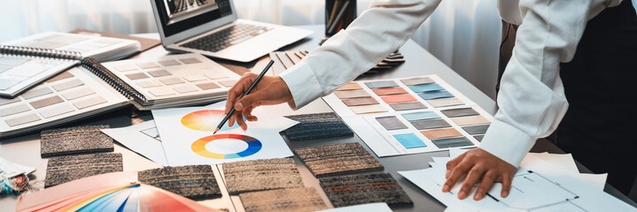 Interior architect designer at table designing hand choosing color samples with architecture...