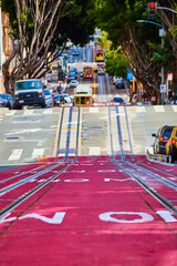 Three streetcars on single road going both uphill and downhill in San Francisco, CA