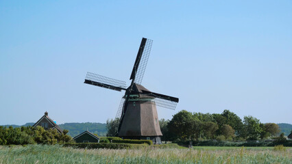 Naklejka premium A traditional Dutch windmill standing on a field in the Netherlands