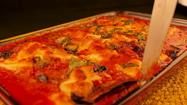 melanzane di parmigiana is a classic Southern Italian dish prepared by thinly fried eggplant slices coated with cheese and tomato sauce and baked in the oven