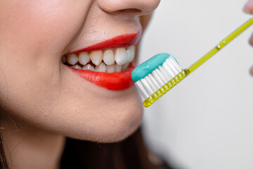 A woman brushing her teeth with a toothbrush. A Morning Routine: A Woman Brushing Her Teeth with a...