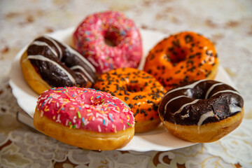 Donuts with multi-colored glaze on a plate for Hanukkah.