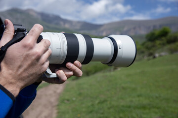 professional photographer with camera in hands outdoors
