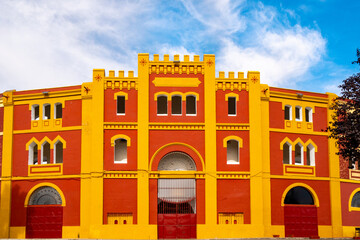 Red and yellow front facade of the Bullring in Mérida, Extremadura in Spain.