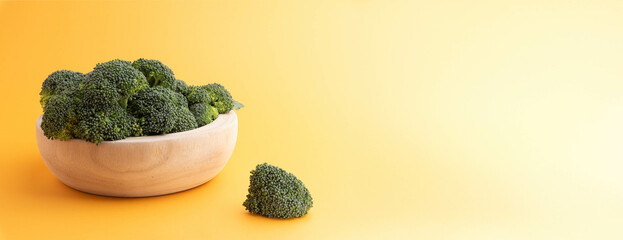 Raw broccoli heaped in a wooden bowl.