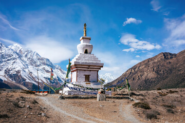 A spiritual monument stands proudly under the clear blue sky, flanked by the majestic Himalayas and...