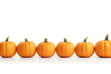 A row of small pumpkins placed on a white surface. This image can be used for autumn-themed designs or Halloween-related projects