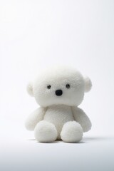 A white  bear sits on a white surface. This versatile image can be used for various purposes