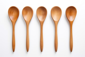 Five wooden spoons neatly lined up on a white surface. Perfect for kitchenware, cooking, and food-related designs - obrazy, fototapety, plakaty