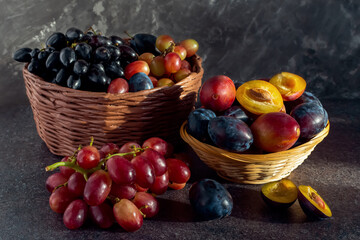 still life of grapes and plums in a basket