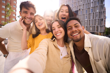 Selfie group of smiling multicultural young friends outdoors. Cheerful people posing happy for...