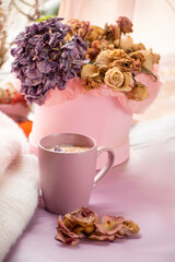 Coffee with milk and cinnamon and warm, soft woolen clothes. everything is in a soft pink color scheme.