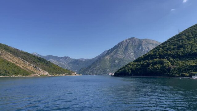 A scenic view of the Bay of Kotor and the coastline of the ship that sails past Kamenare and Lapetane, Montenegro