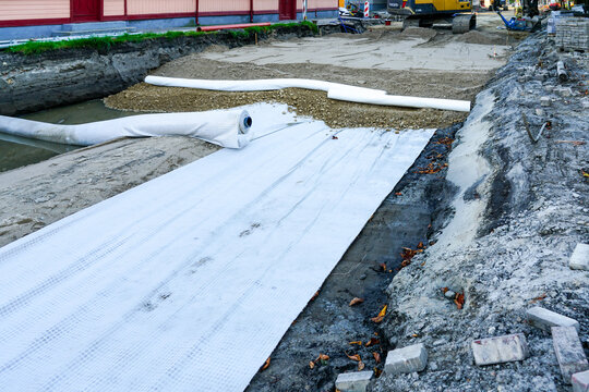 Use of geotextile fabric rolls for drainage and separation of base layers in street reconstruction