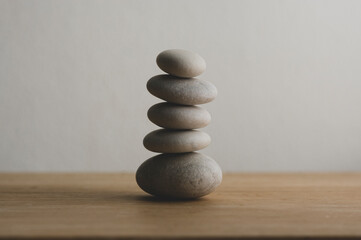 Stone cairn on white background, five stones tower, simple poise stones, simplicity harmony and balance, rock zen