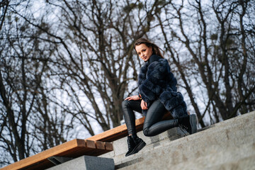 A woman sitting on top of a cement bench. A Serene Moment on a Weathered Cement Bench, Enjoying Solitude and Nature's Beauty