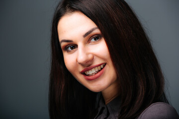 A woman with long dark hair smiling at the camera. The Enchanting Smile of a Woman with Long Dark...