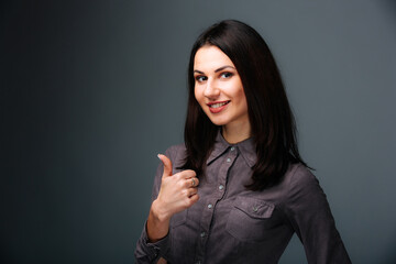 A woman is giving a thumbs up sign. A Woman Expressing Approval and Positivity with a Thumbs Up...