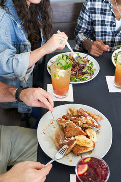 Friends at restaurant having brunch salad and French toast