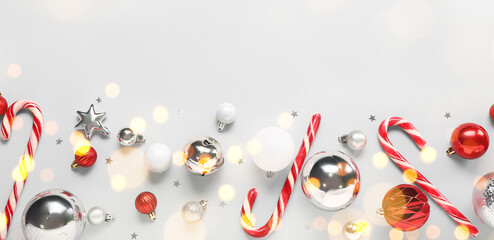Christmas balls with candy canes on light background, top view