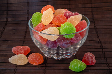 jelly fruit in glass bowl on a wooden dark background