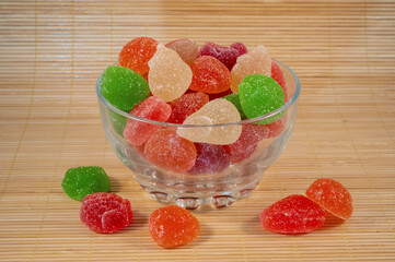 jelly fruit in glass bowl on a wooden light background