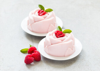 Raspberry Cream dessert, Panna Cotta in the shape of a rose, on a plate. Light background