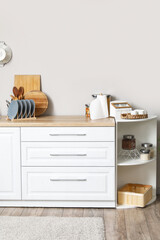 White kitchen counters with cutting boards, plate rack and utensils