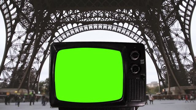 Old Television Turning On Green Screen Against The Base of the Eiffel Tower in Paris, France. You can replace green screen with the footage or picture you want with “Keying” effect.