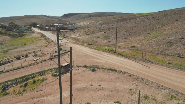 Pan around electricity transformer perched on elevated poles above the ground at entrance to town of Lekkersing, Richtersveld