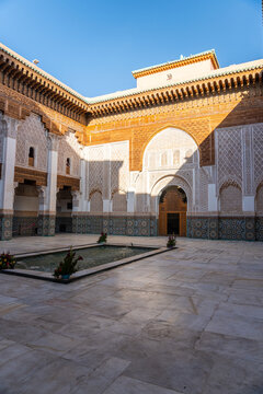 Inner courtyard of the Ben Youssef medersa, inner courtyard full of tiles and a fountain. Sunny day.