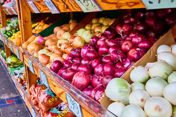 Onions and produce in outdoor market with dirty tile ground, unclean, unsanitary