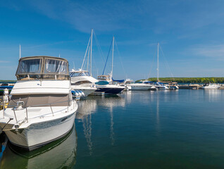 Fototapeta premium Beautiful morning scene, with motor boats and sailboats moored to the docks in the marina.