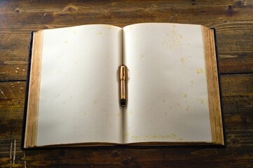 Opened old book with aged pages with a pen between pages 