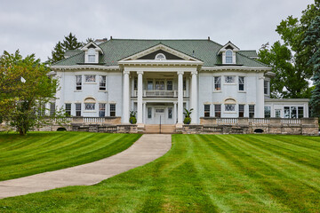 Large white estate house with green lawn and small vegetable garden, Muncie, IN - obrazy, fototapety, plakaty