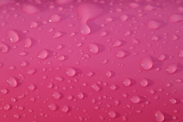 Drops of water after summer rain on pink color children's inflatable ball