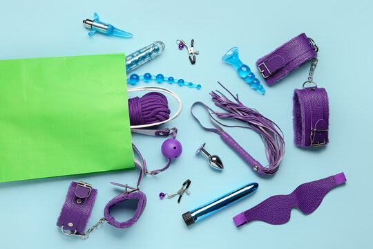 Shopping bag with sex toys on blue background