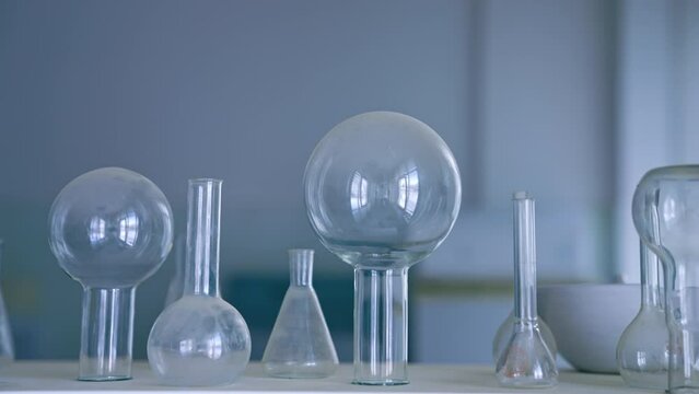 Glass flasks and beakers on the table. Medical laboratory appliances. Close up.