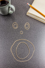 Face made out of rubber bands on office desk