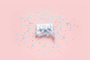 White gift box with confetti on pink background