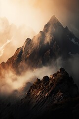 A high mountain peak shrouded in clouds at sunrise