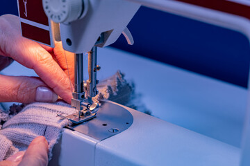 Sewing on a machine repairing clothes. A seamstress sews on a machine in a sewing room